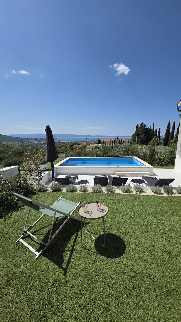 MareVista heated pool area with sun loungers and parasols