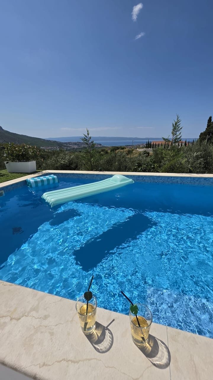 MareVista heated pool in the evening with warm lighting and sea view backdrop in Kučine